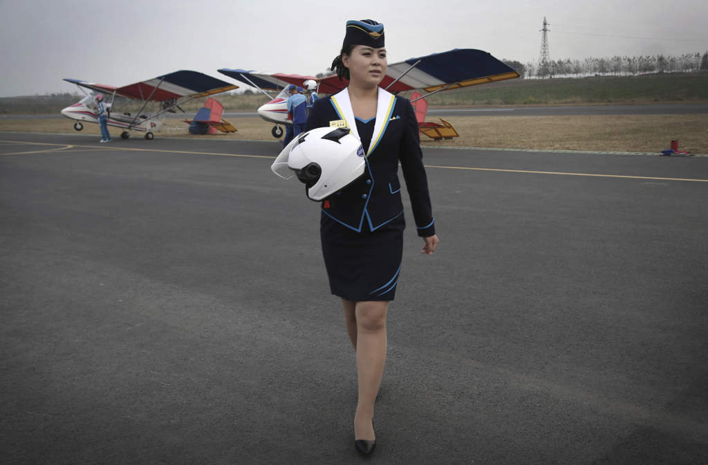 En anställd på Mirims flygklubb bär en hjälm över landningsbanan, den 16 oktober 2016. Under 2016 kunde vissa nordkoreaner för första gången ta korta flygturer över huvudstaden, ett led i Kim Jong-Uns löfte att erbjuda folket mer moderna fritidssysselsättningar. Foto: AP