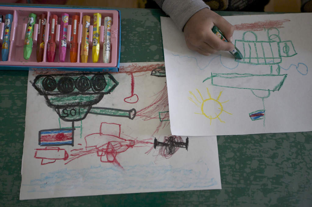 Ett barn ritar stridsvagnar och vapen under en bildlektion i en förskola i Pyongyang, den 27 april 2012. En stor del av barnens skolgång handlar om politisk indoktrinering – för klanen Kim, mot USA, Sydkorea och Japan. Foto: Vincent Yu/AP
